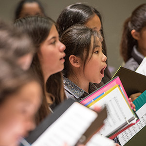 a young chorus singing during a rehearsal