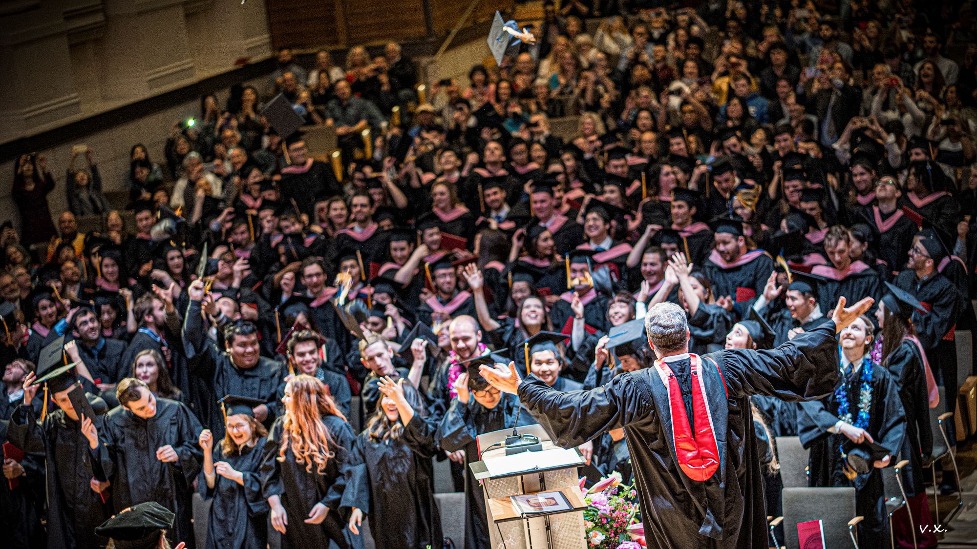 The Full Student Body smiling before throwing their caps at commencement