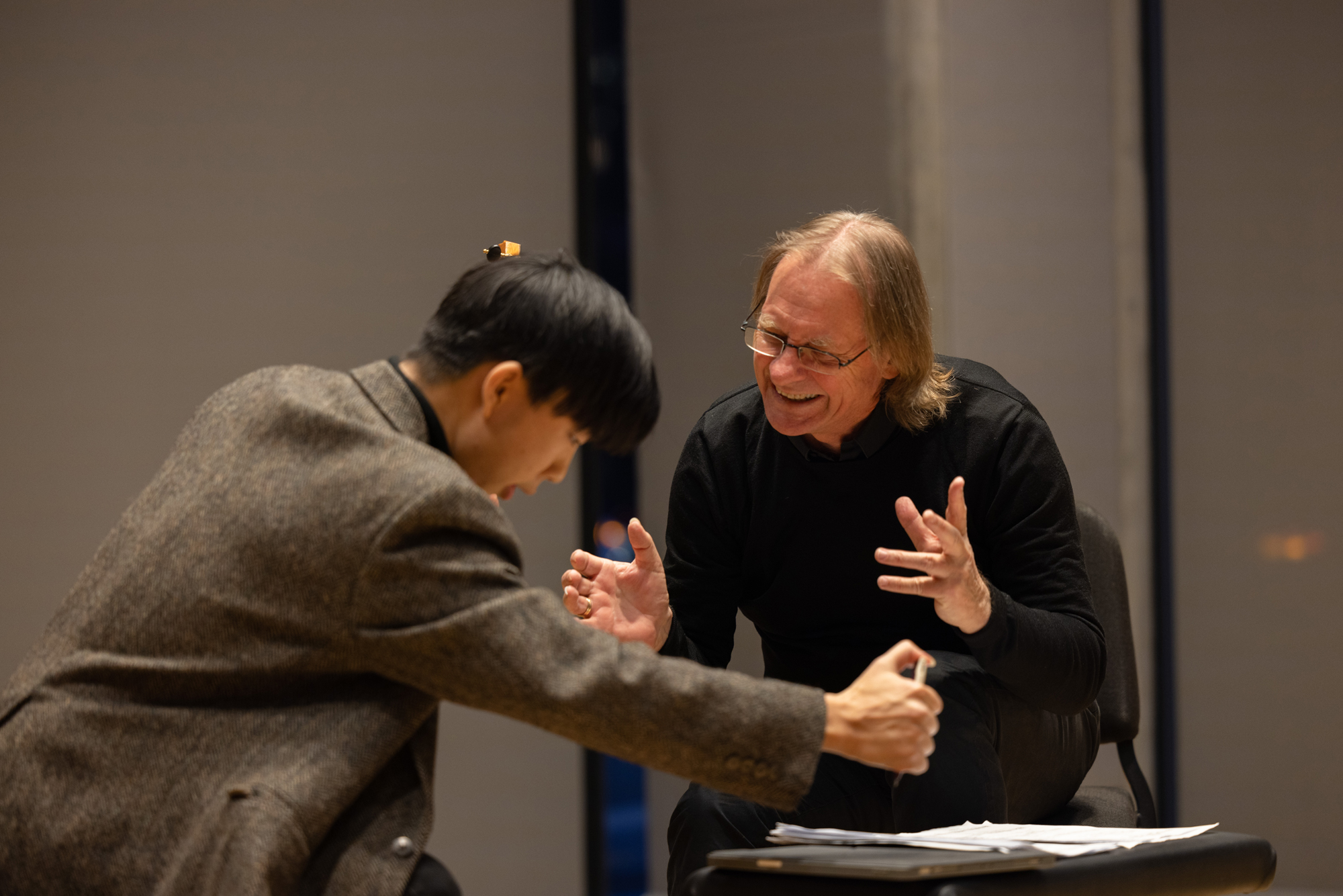 David Russell gestures musically with a student in a masterclass setting