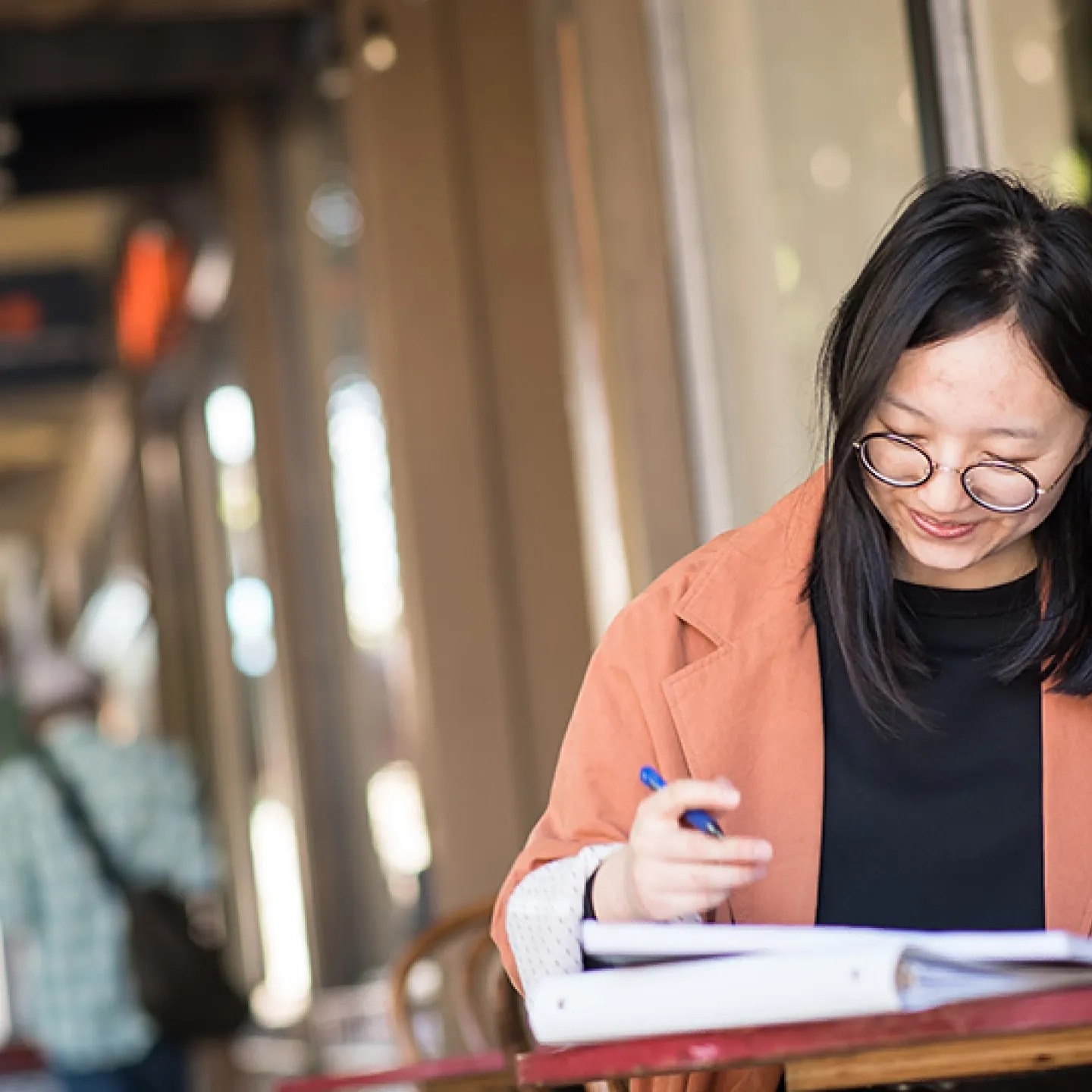 student working in a binder at a small table