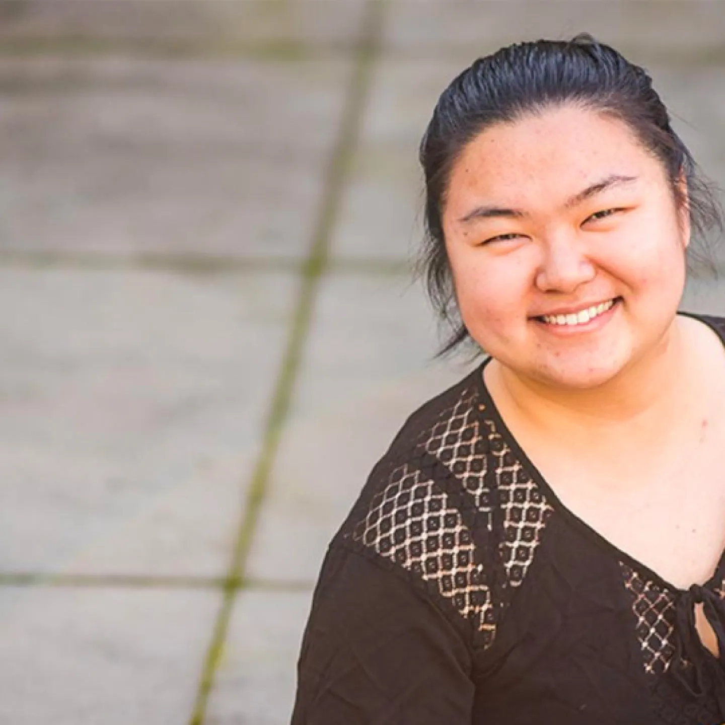 smiling student holding string instrument