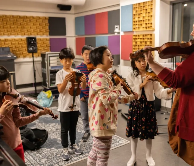 a group of pre-college violinists watching a teacher