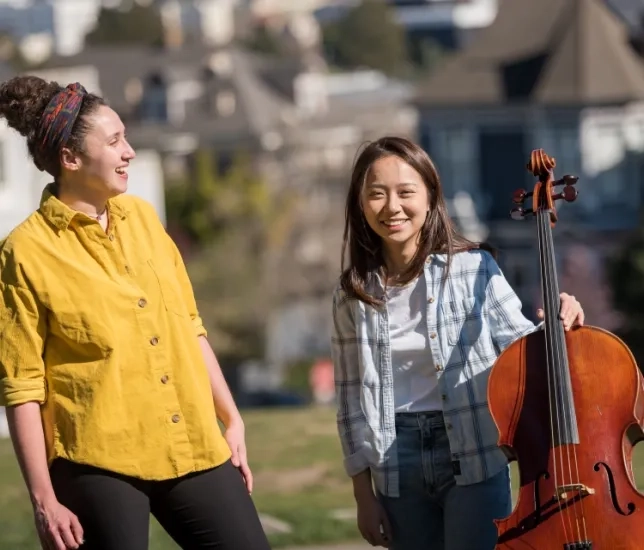 two students smile in alamo square