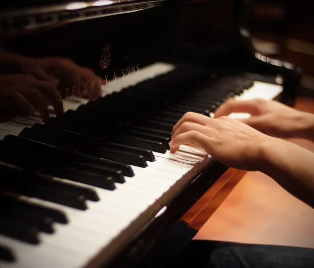 Hands playing on piano. 