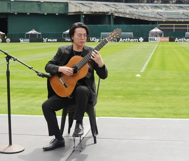 Mario To performing on guitar. 