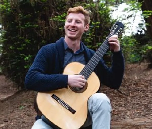 SFCM student playing guitar outside
