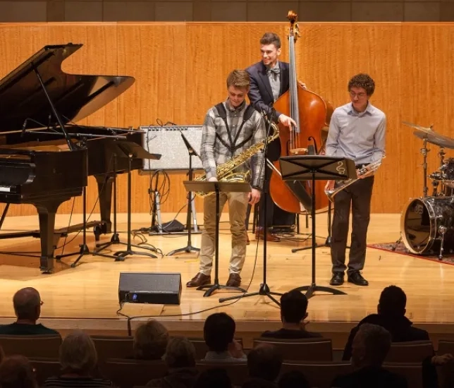 A photo of students with Simon Rowe performing
