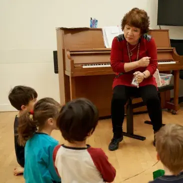 Young children play with bells in a semi-circle