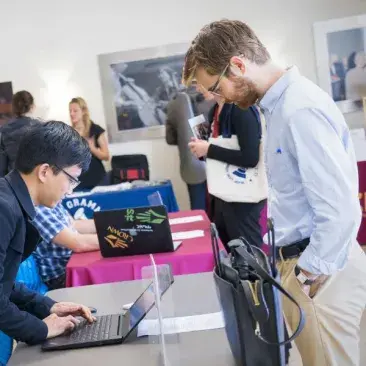 a student leans over a table at a job fair