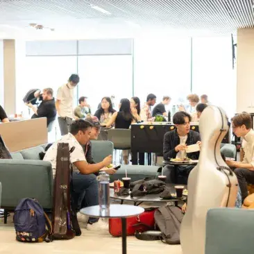 a lively lounge in the bowes center with students eating and talking