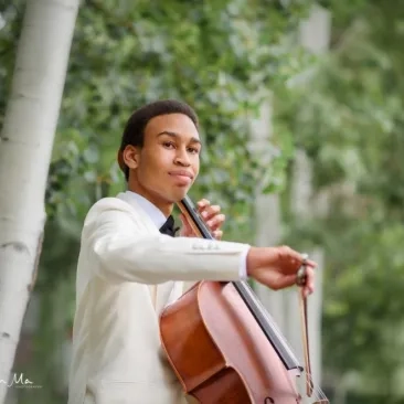 quenton blache headshot with cello outside