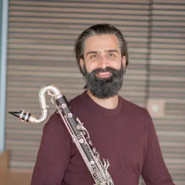 Jeff anderle smiling and holding a bass clarinet