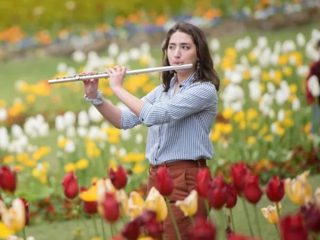 a flute student plays outside among the tulip gardens in san francisco