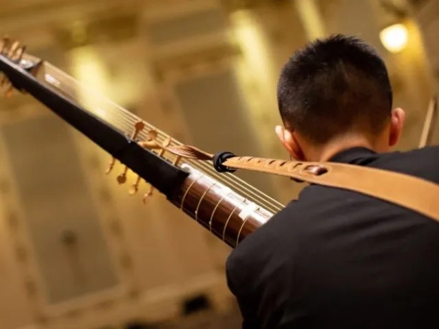  a student playing a historical instrument in the concert hall