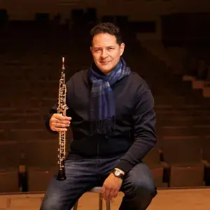 Eugene Izotov headshot while holding an oboe