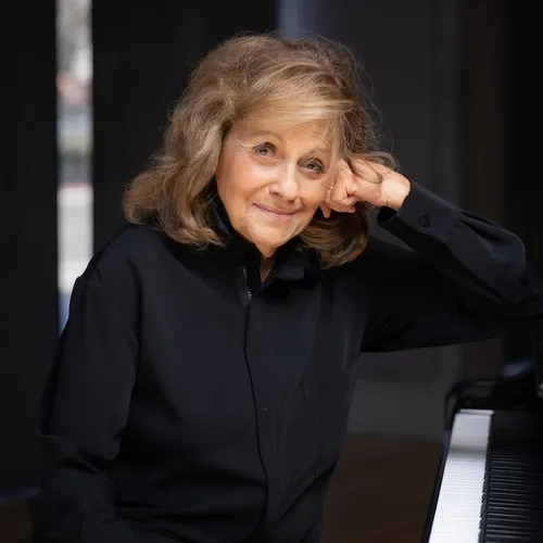 Sharon Mann headshot sitting at the piano