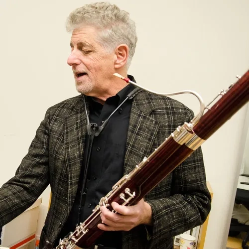 Stephen Paulson headshot while holding bassoon