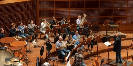 a conductor conducts rehearsal with sfcm and sfs players on davies stage