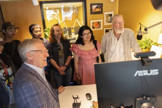 KDFC President Bill Lueth (left foreground) and Production Manager Stephen Page (at microphone) guide students through the KDFC studios.