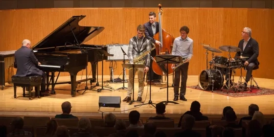 A photo of students with Simon Rowe performing