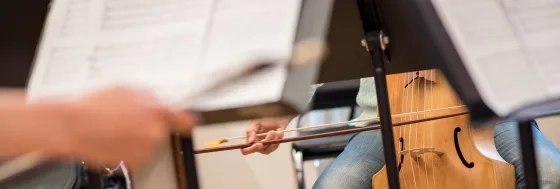 a student playing a historical bowed instrument