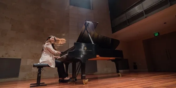 a student performing at the piano, hair is in motion