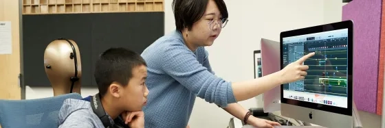 Pre-College Student working on computer with composition