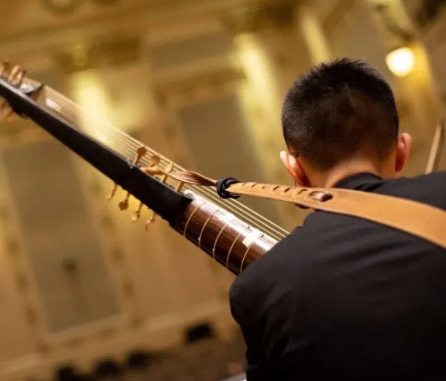 a student playing a historical instrument in the concert hall