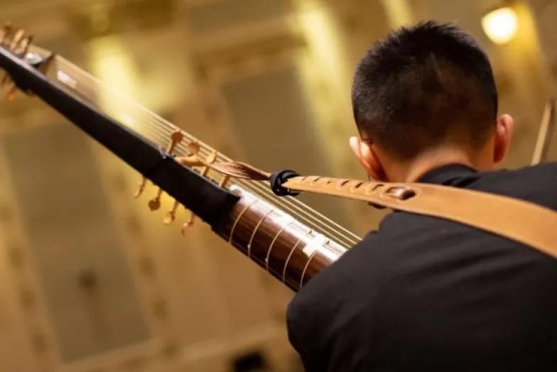 a student playing a historical instrument in the concert hall