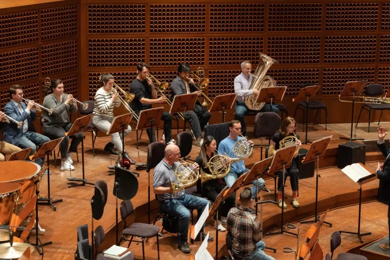 a conductor conducts rehearsal with sfcm and sfs players on davies stage