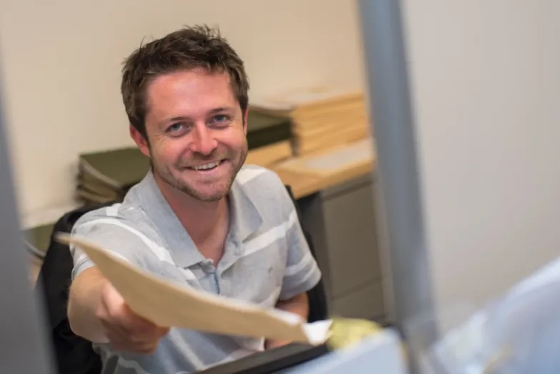 a man hands you a manila folder
