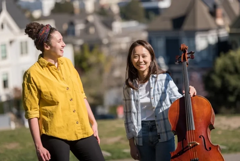 two students smile in alamo square