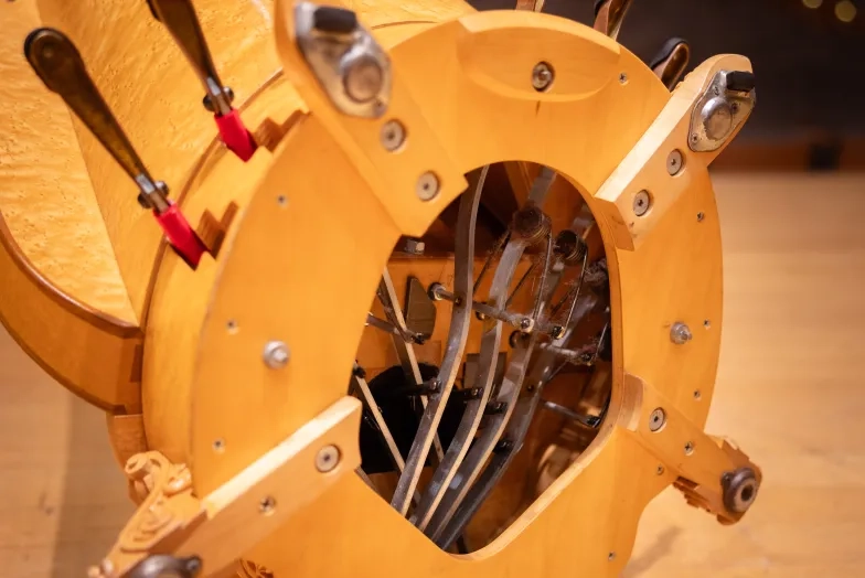 A close-up of how a concert harp's pedals are anchored in the column.