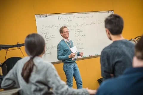 Jack Van Geem project management and musical brain teaching students in class