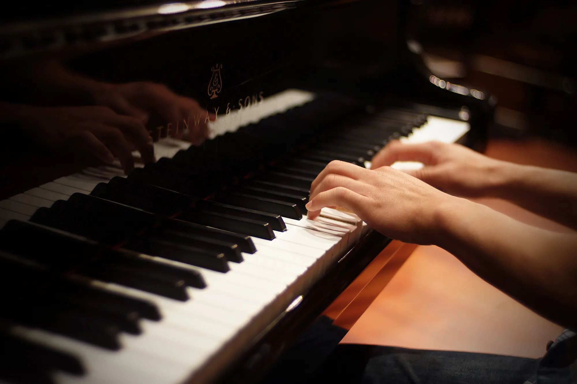 Hands playing on piano. 